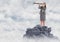 Business woman with telescope on mountain peak in the clouds