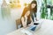 Business woman using laptop and cell phone on tree garden at home, Young women conducting business from home.