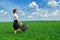 Business woman walk on green grass field outdoor. Beautiful young girl dressed in suit, spring landscape, bright sunny day