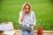 Business woman wearing white shirt and jeans sitting in the park