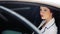 Business woman in the window of his official car. Beautiful young woman sitting in the car. Portrait of a pretty business woman in