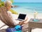 Business woman working with computer on the beach