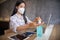 Business woman working from home wearing protective mask and using alcohol gel pump bottle at home. Coronavirus outbreak.