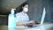 Business woman working from home wearing protective mask and using laptop computer. Coronavirus outbreak