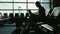 Business woman working with laptop in airport terminal. Waiting for my flight. Silhouette against the background of a
