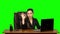 Business woman working on a laptop smiling joyfully and showing ok sign, while looking at the camera. Green screen