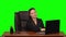 Business woman working on a laptop smiling joyfully and showing ok sign, while looking at the camera. Green screen. Slow