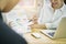 Business women present financial documents on wooden desk in office in morning light. The concept is ready to offer to customers