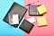 Business and work concept. Office tools isolated on pink and blue background, top view. Calculator, hole punch, business