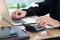 Businessman or accountant hands using calculator and laptop computer to calculate financial data, cost and budget on desk at