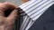 Businessman adjusts collar of stylish striped shirt by hands