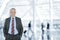 Businessman in Airport with Blurred Travelers in background