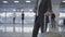 Businessman in the airport with his phone and suitcase