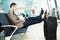 Businessman at airport with smartphone and suitcase