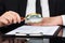 Businessman analyzing document with magnifying glass at desk