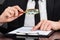 Businessman analyzing document with magnifying glass at desk