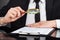 Businessman Analyzing Document With Magnifying Glass At Desk