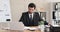 Businessman analyzing document and writing notes at desk