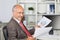 Businessman Analyzing Documents At Office Desk