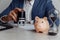 Businessman approves important contract. Piggy bank with stack of coins and hourglass on desk close-up. Time is money