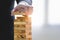 Businessman arranging wood block and stacking as tower by hand. Business organization and company growth progress. Success of