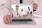 Businessman attending online video conference via laptop at table in office, closeup