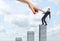 Businessman balancing on vertical concrete column with a giant female hand pointing at him.