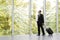 Businessman in black formal wear holding trolley bag