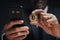 Businessman in black suit holding a golden bitcoin using Smartphone with Bitcoin trading chart on the screen to Trading