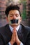 Businessman with a black tape in his mouth asking for mercy , in a blurred background