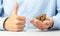 Businessman in blue shirt holds in his hand lot of coins. Positive thumbs up, like