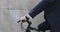 A businessman in a blue suit is riding a bicycle against a gray concrete wall.