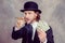 businessman with bowler hat in black suit showing money and smoking big cigar