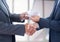 Businessman bribing partner while shaking hands