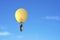 Businessman in brightly yellow lamp hot air balloon flying