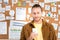 Businessman in brown shirt using smartphone in office