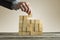 Businessman building a structure with wooden cubes on table surf