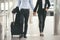 Businessman and Businesswoman Dragging suitcase luggage bag, walking to passenger boarding in Airport. Couple of love travel to