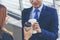 Businessman Businesswoman drink coffee in town outside office modern city. Hands holding take away coffee cup talking together