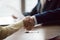 Businessman and businesswoman hands shake at meeting, close up view