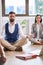 Businessman and businesswoman meditating at work. Coworkers sitting on the floor