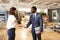 Businessman And Businesswoman Meeting And Shaking Hands In Modern Open Plan Office