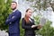 Businessman and businesswoman realtors with laptop outside, asian kazakh entrepreneurs discuss project