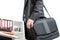 Businessman carrying his laptop suitcase on his shoulder