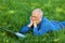 Businessman Chatting Online On Laptop While Lying On Grass