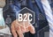 The businessman chooses  B2C, Business-to-consumer on the touch screen with a futuristic background .The concept B2C, Business-to-