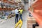 Businessman with clipboard and loader at warehouse