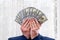 Businessman closed his face with dollar fan.