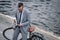 businessman with coffee to go and smartphone standing with bike