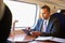 Businessman Commuting On Train Using Digital Tablet